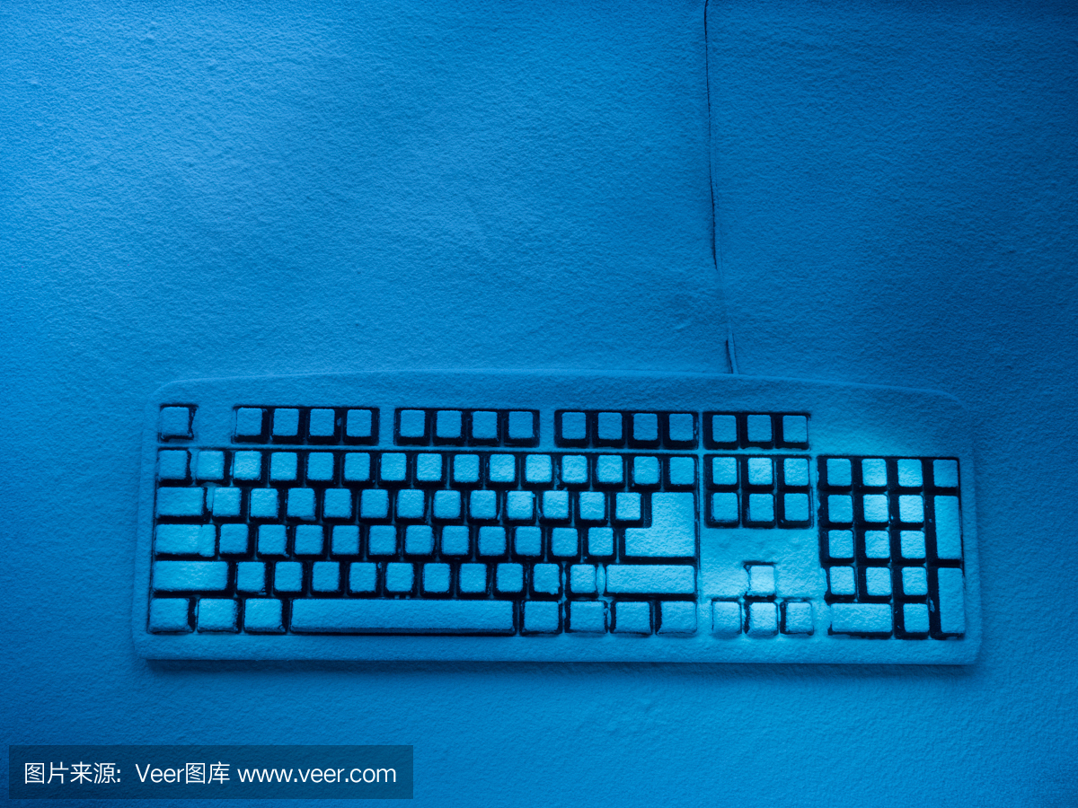电脑键盘上覆盖着雪,用蓝色的霓虹灯和一些明亮的按钮照明